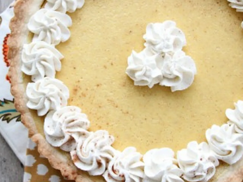 Close-up of pumpkin pie tart with whipped cream garnish