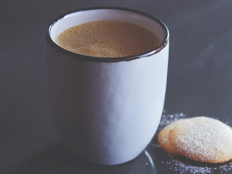 Mug of pumpkin spice latte next to wafer cookies