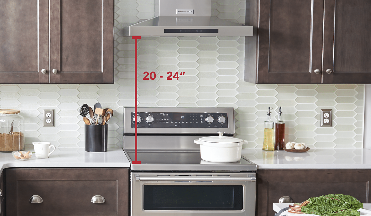 Stainless steel KitchenAid® range and range hood with measurements set in brown cabinetry