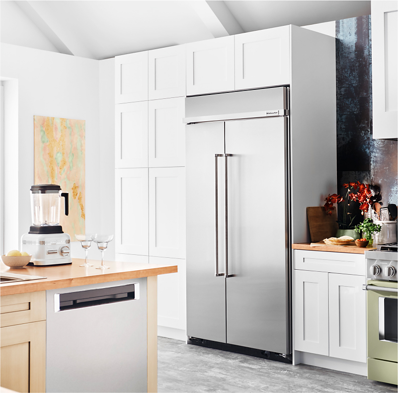 A built-in KitchenAid® refrigerator surrounded by white cabinetry.