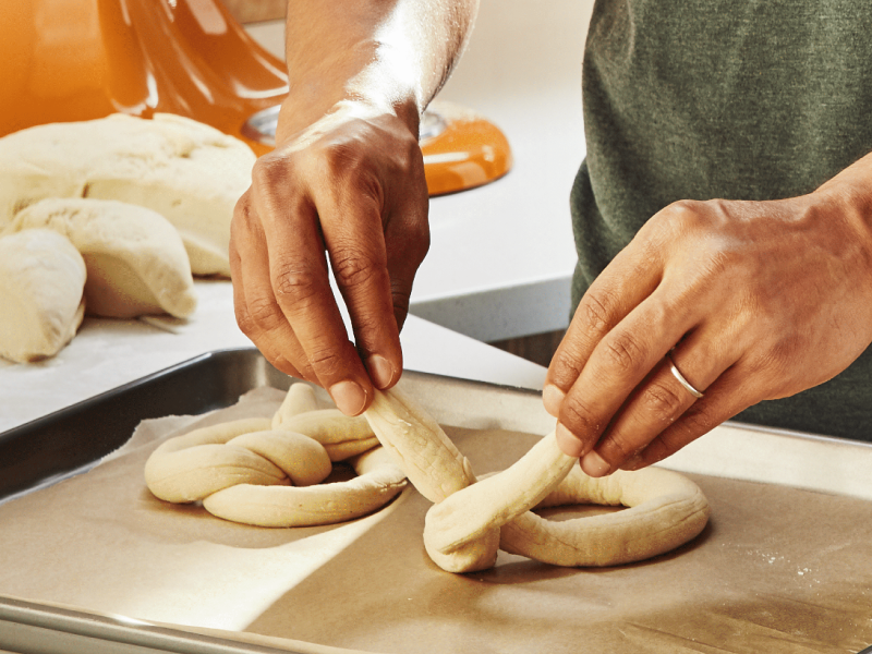 Person twisting dough into a pretzel shape 