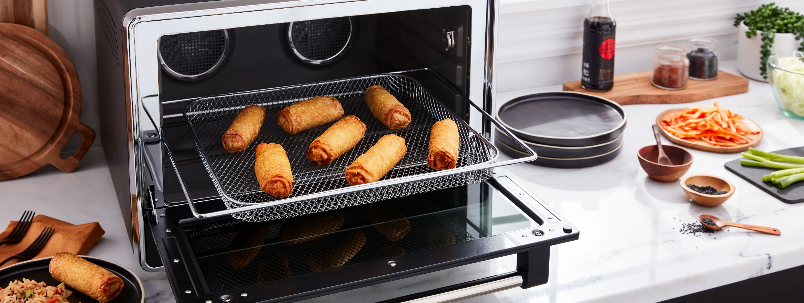 Egg rolls being removed from a toaster oven