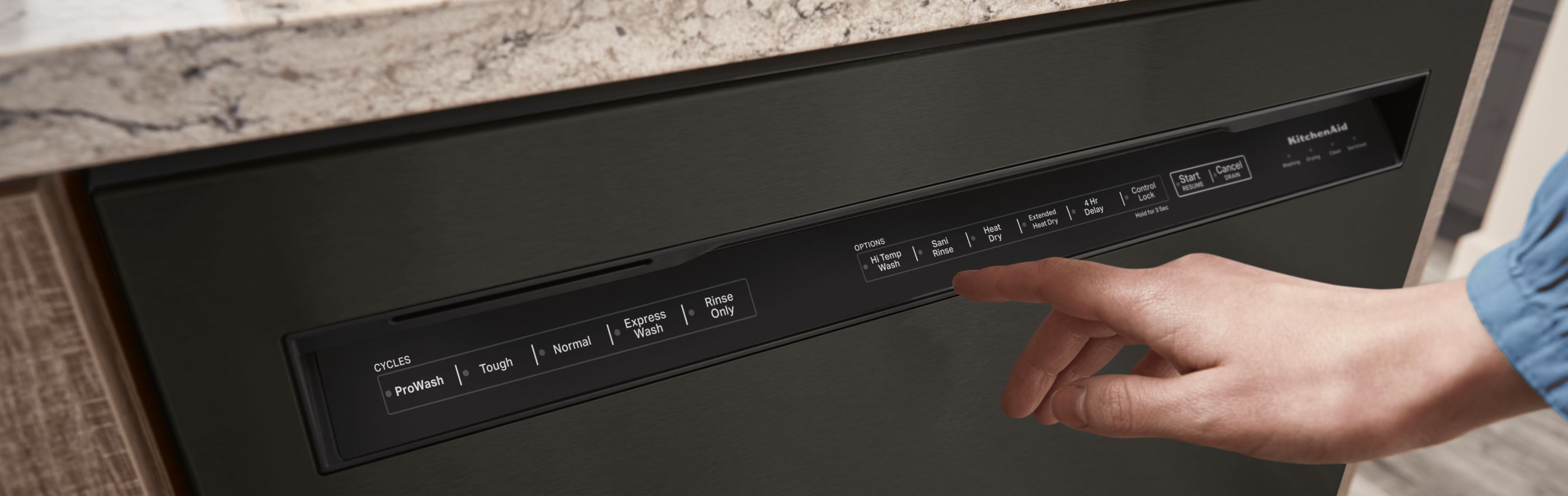 Hand touching a KitchenAid® front control dishwasher