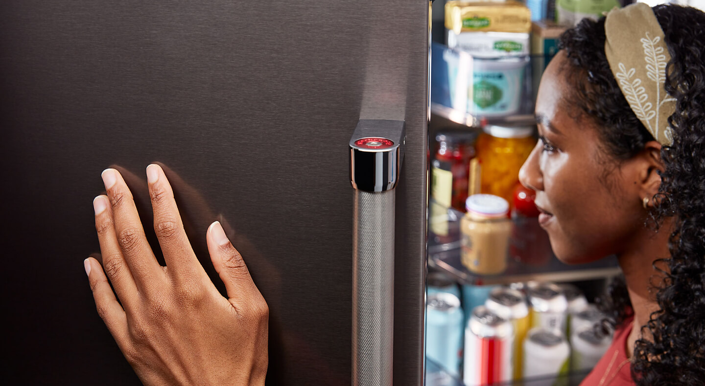 Person holding door open on KitchenAid® refrigerator