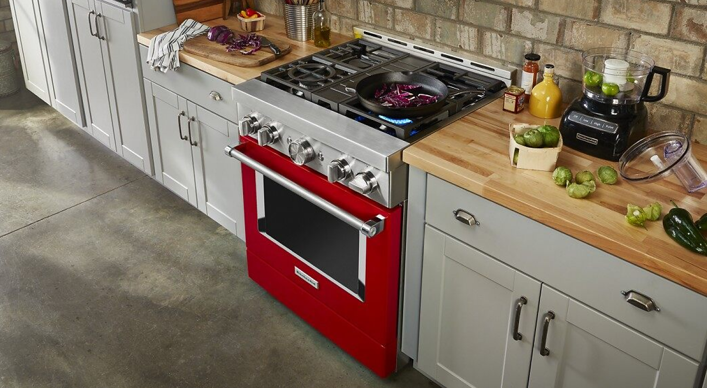 Red KitchenAid® range with pan cooking on gas burner