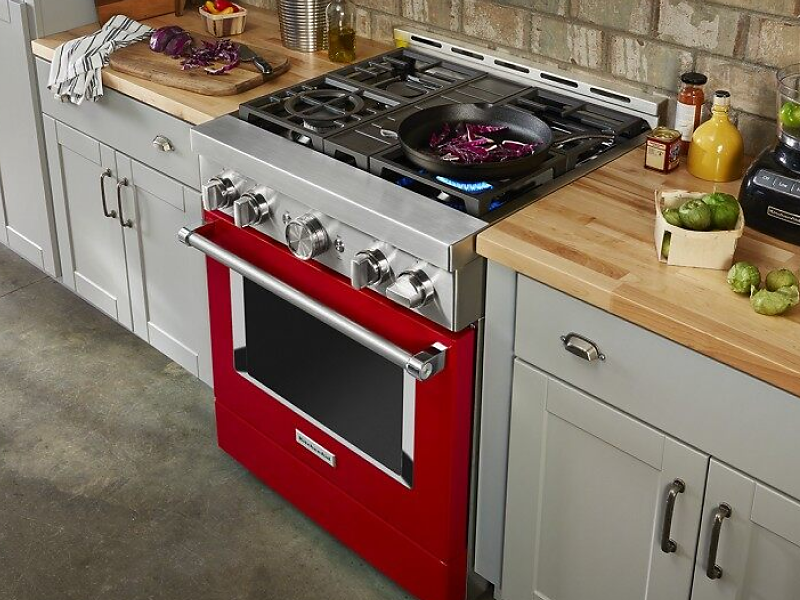 Red KitchenAid® range with pan cooking on gas burner