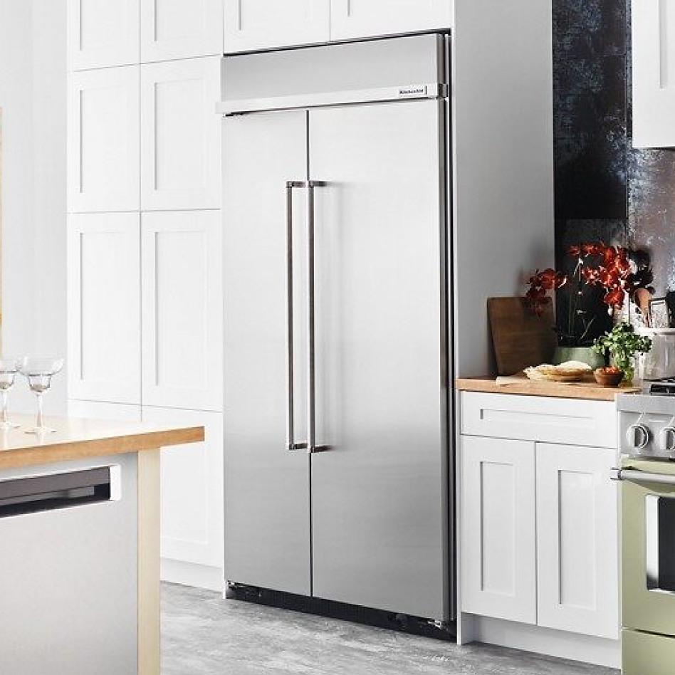 Built-in refrigerator style installed in white cabinets in modern kitchen