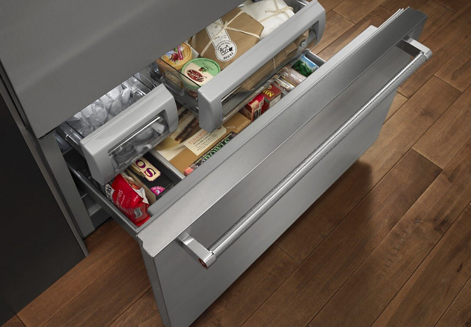 Open bottom freezer refrigerator drawer with food inside
