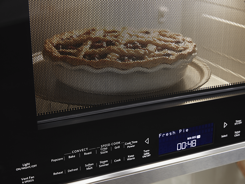 A closeup of a KitchenAid® microwave baking a pie.