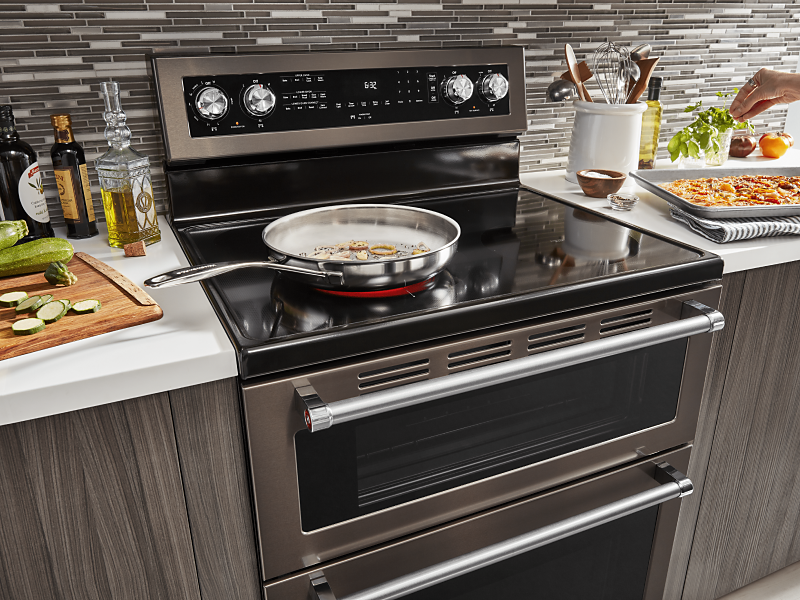 Large skillet cooking food on the electric stovetop of a KitchenAid® double oven range