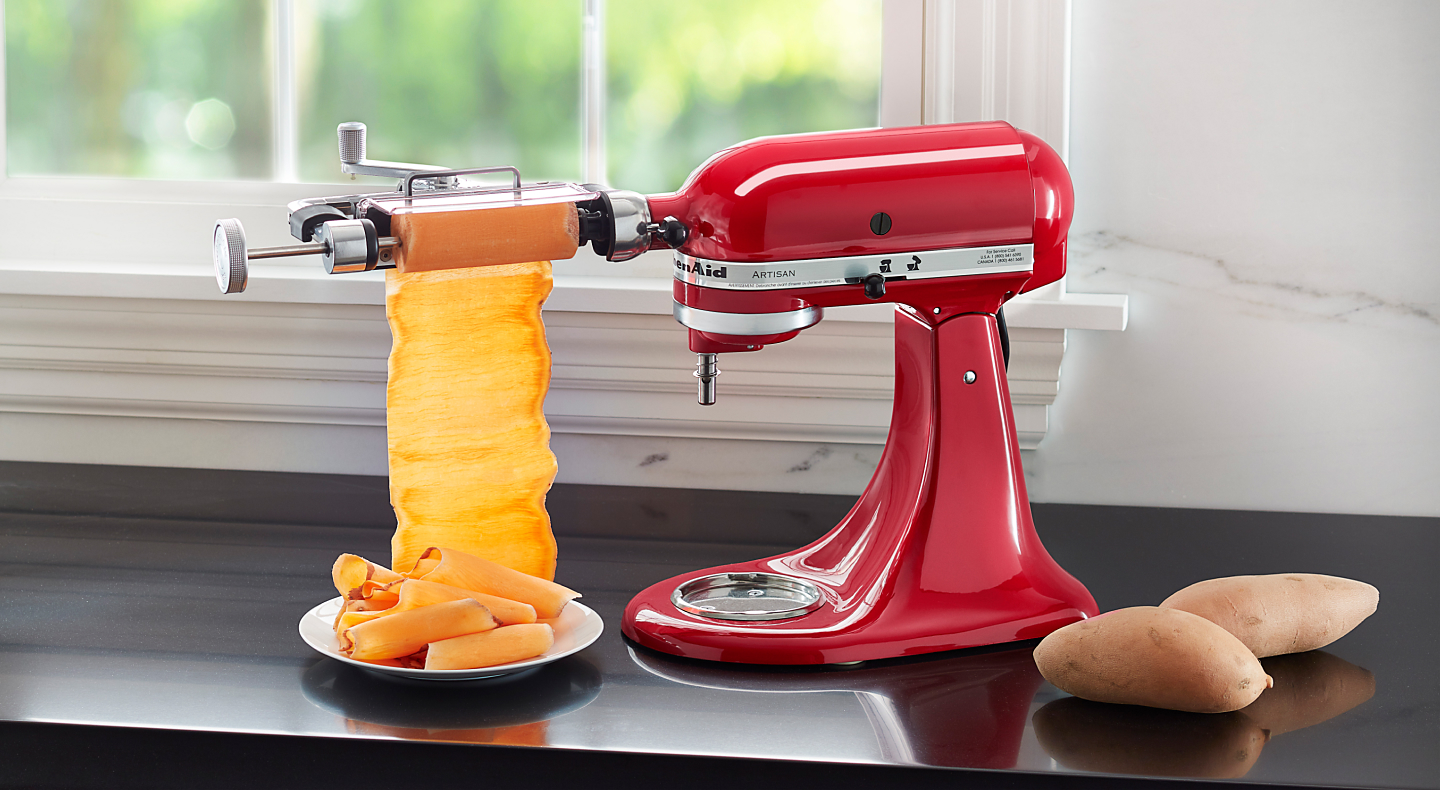 Red KitchenAid® Stand Mixer with Vegetable Sheet Cutter cutting carrots