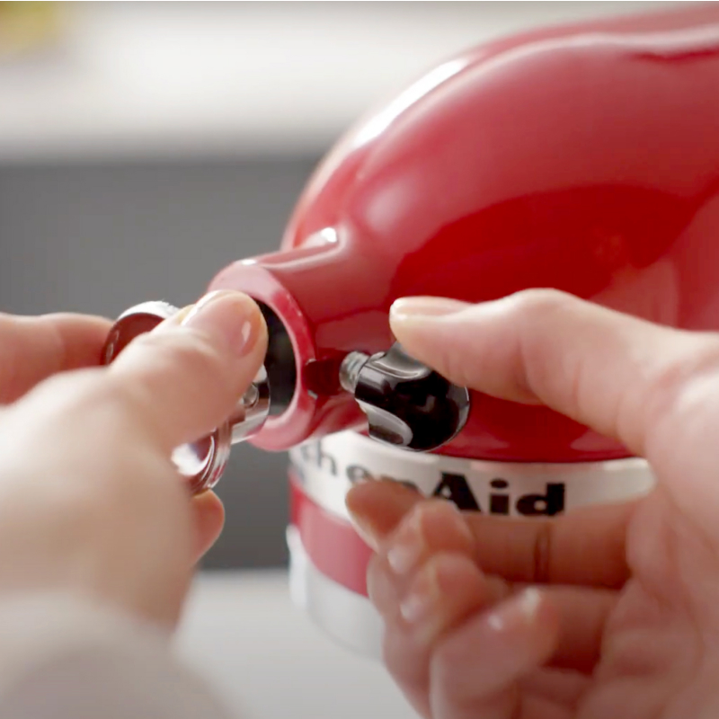 Person securing the attachment to a KitchenAid® stand mixer