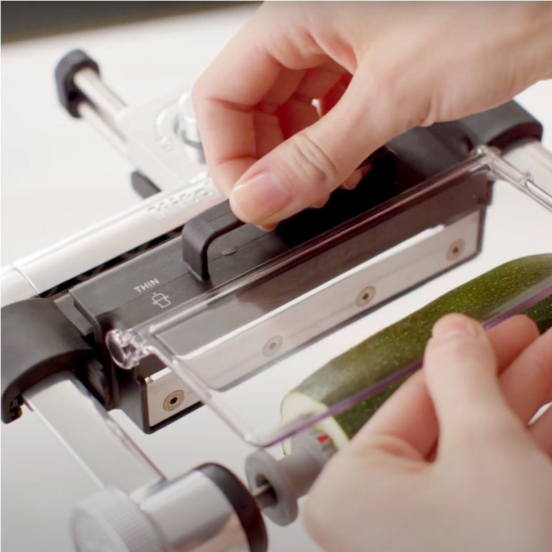 Person selecting the blade on a KitchenAid® Vegetable Sheet Cutter Attachment
