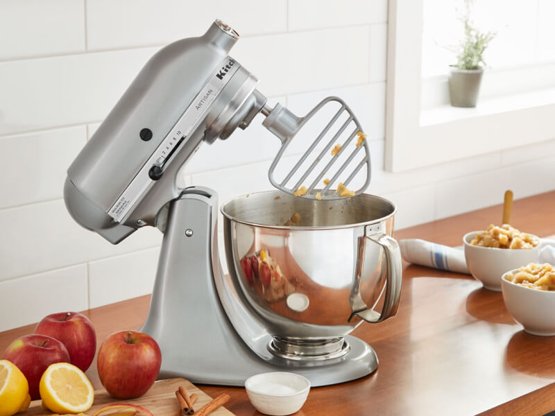 A KitchenAid® stand mixer with a pastry beater accessory on the counter of a modern kitchen.