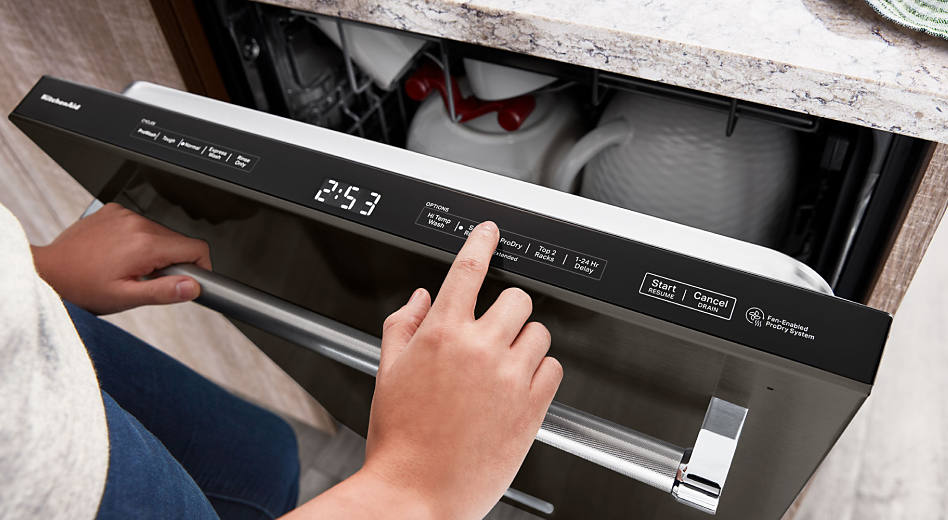 Person using the top control panel of a built-in dishwasher