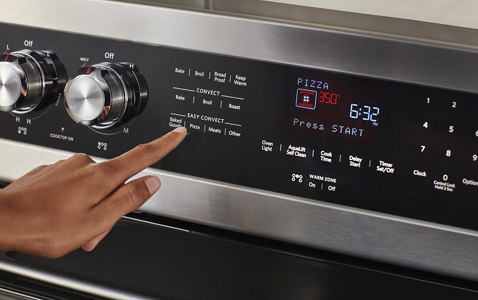 Hand selecting convection conversion setting on KitchenAid® oven