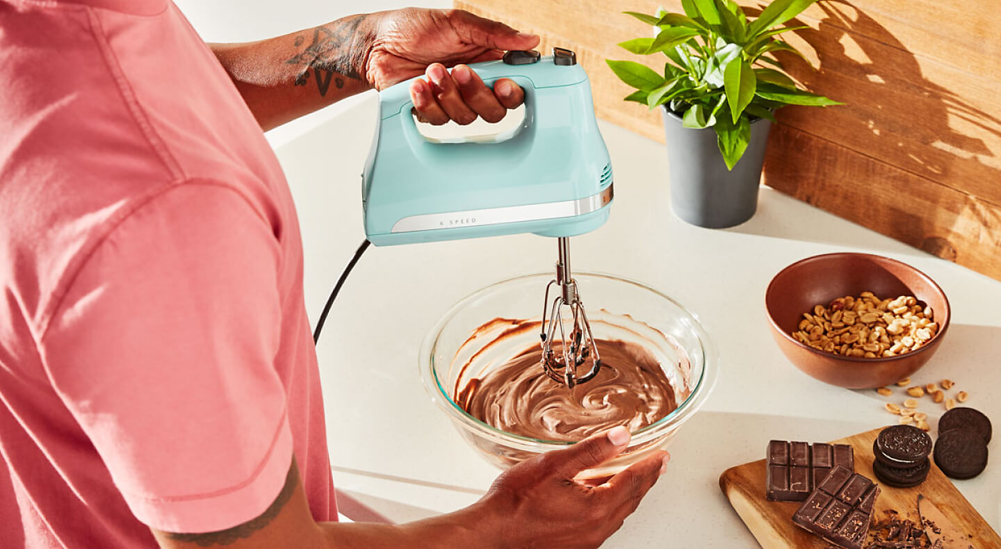 A KitchenAid® hand mixer mixing ganache