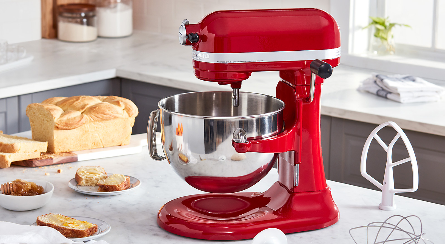 A red KitchenAid® stand mixer amongst various baking ingredients