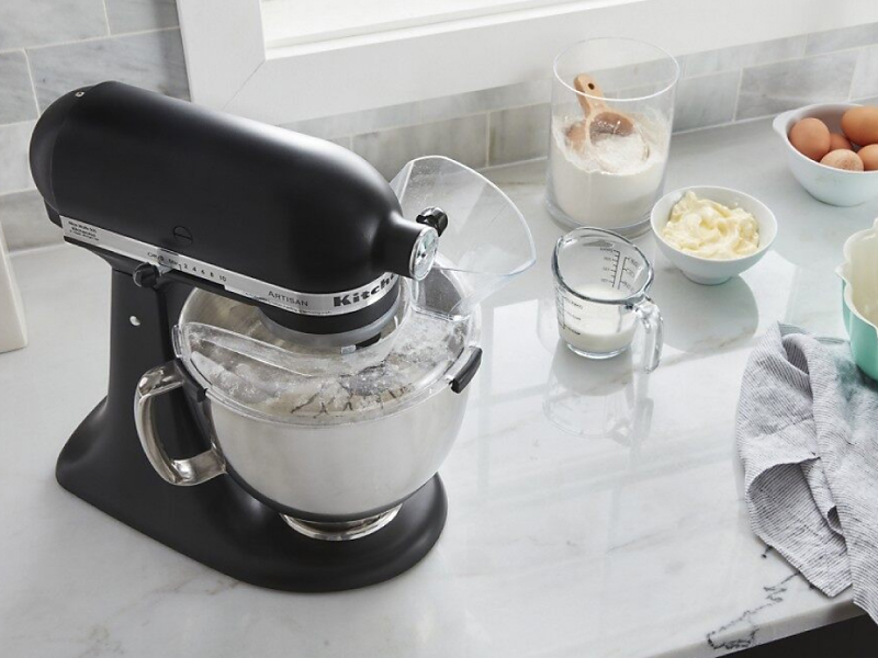A black KitchenAid® stand mixer and various kitchen items on a countertop 