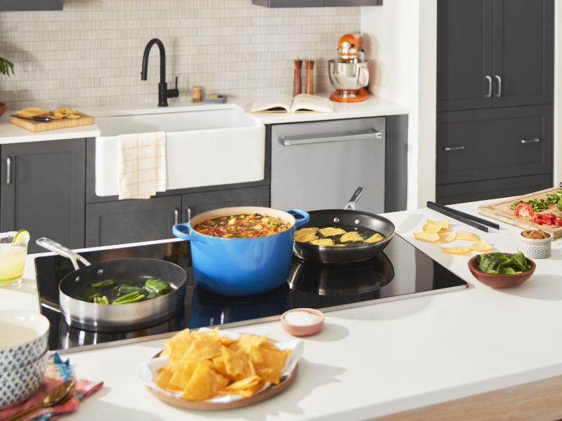 Cooktop with foods cooking in saute pans and dutch oven