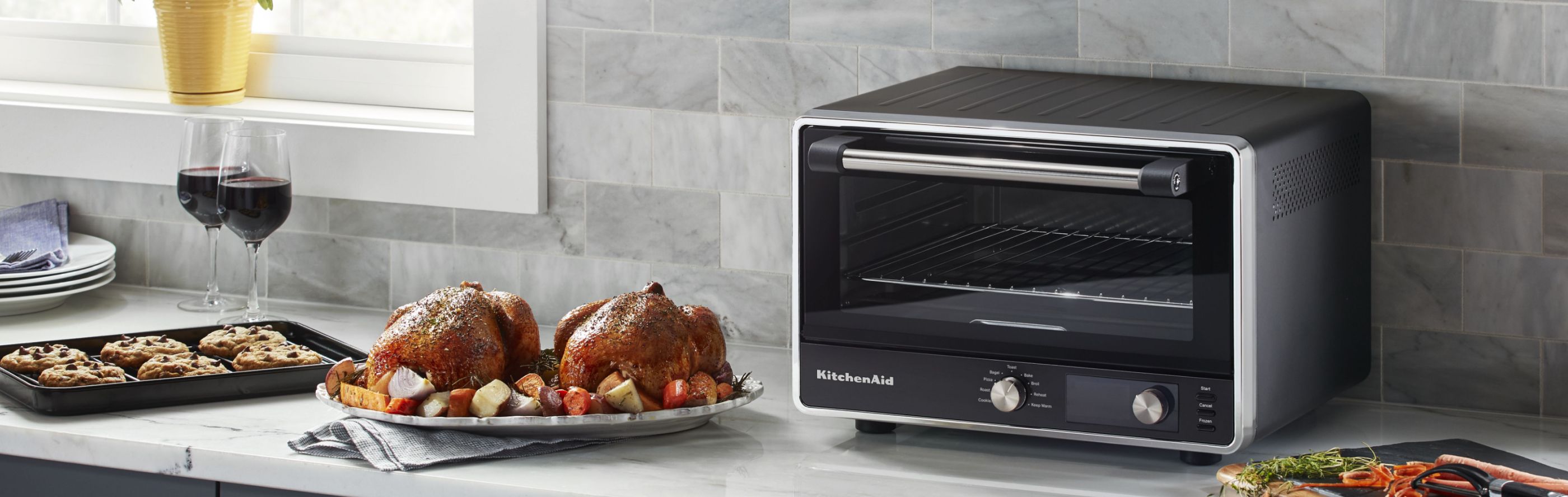  KitchenAid countertop oven with roasted chicken and vegetables on the side