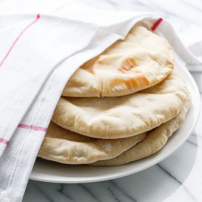 Pita bread on a plate covered with a cloth