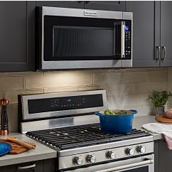 A person using a KitchenAid® microwave.