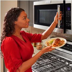 A person using a KitchenAid® microwave.