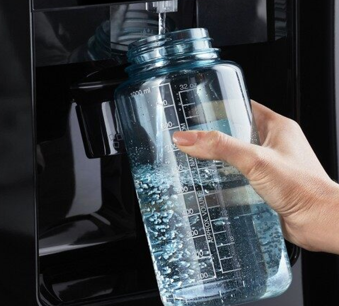 A person refilling a reusable water bottle.