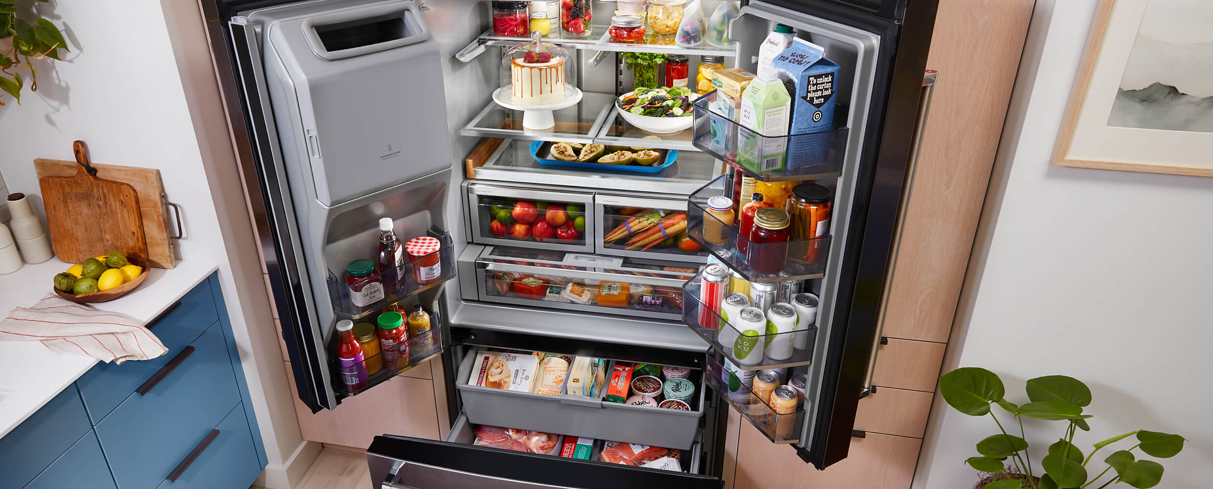 A fully loaded KitchenAid® French Door Bottom Mount Refrigerator with the doors and drawers open.