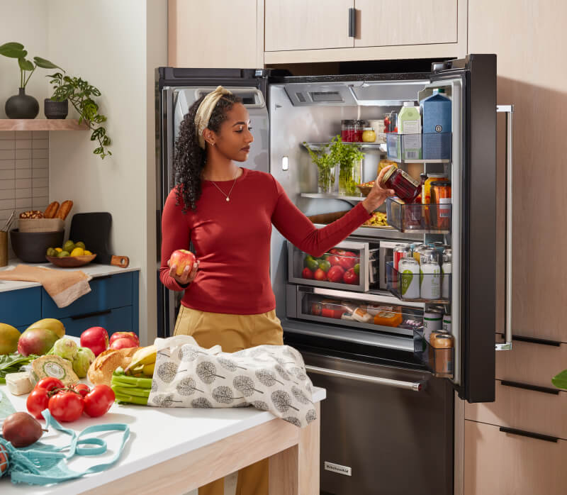 KitchenAid® French Door Bottom Mount Refrigerator actively being loaded.