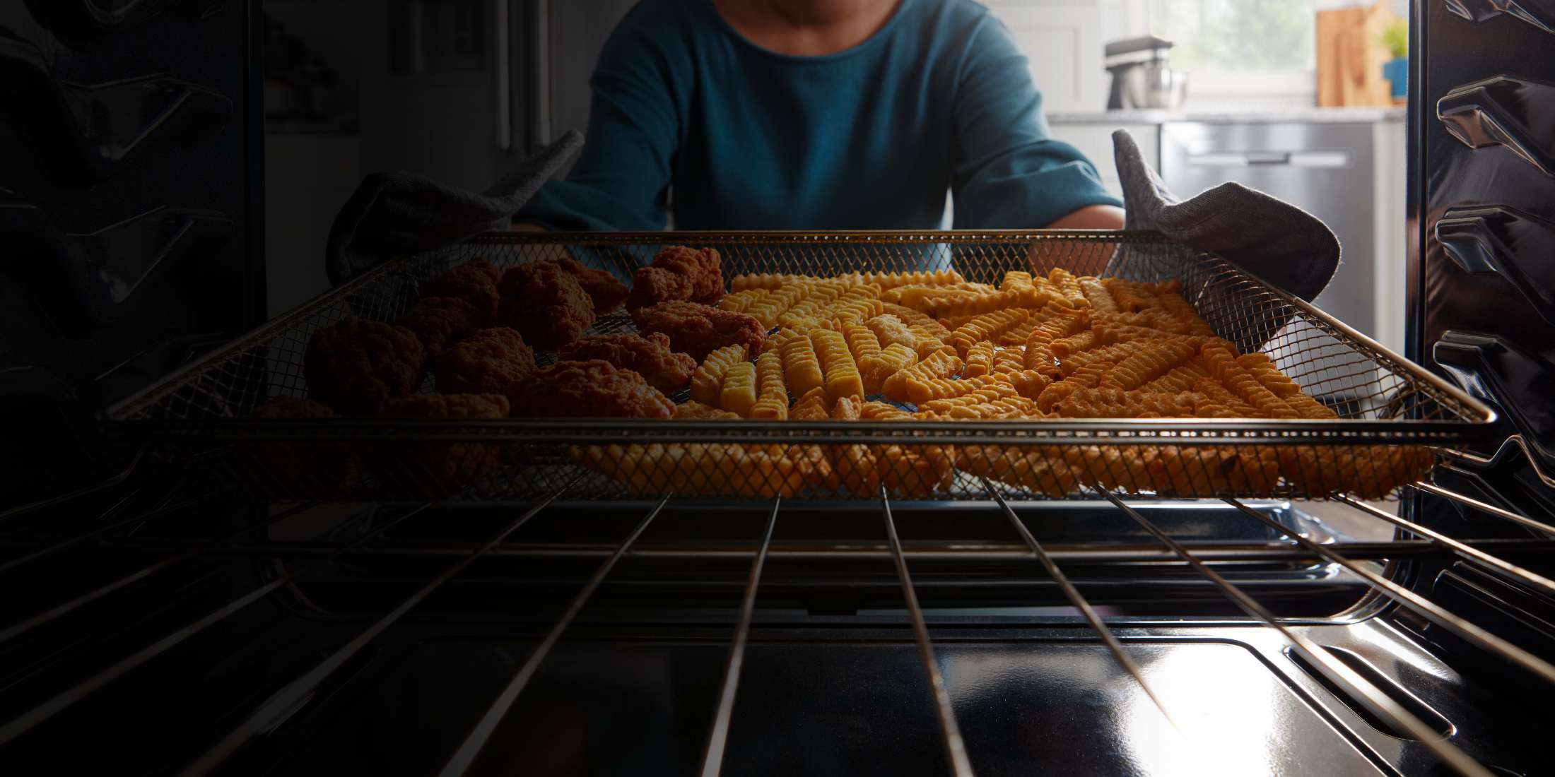 Fries and chicken wings in the dishwasher-safe air fry basket.