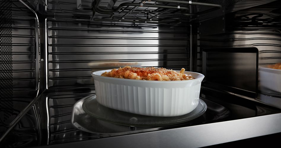 Inside a Maytag microwave. A casserole in a baking dish is on the tray in the centre