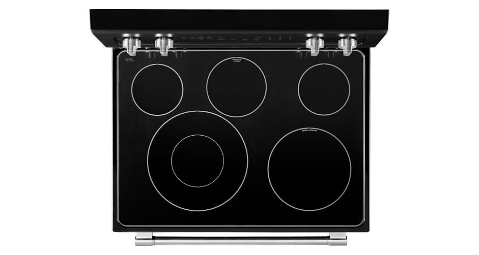 A bird's eye view of a cooktop with four knobs and five burners