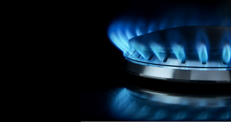 A close-up image of a gas burner with a blue flame.