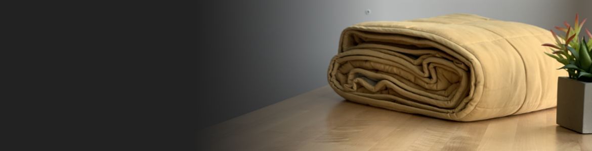 A folded blanket on a wooden counter.