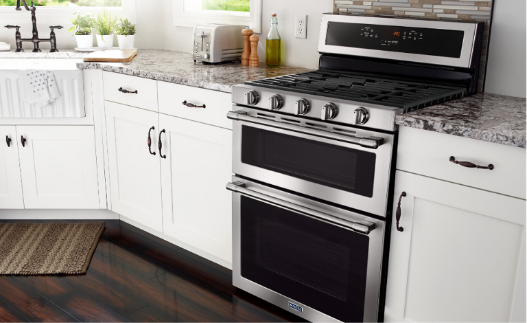 A modern kitchen with a Maytag double oven gas range.