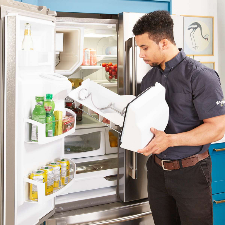 Appliance repair professional working on refrigerator