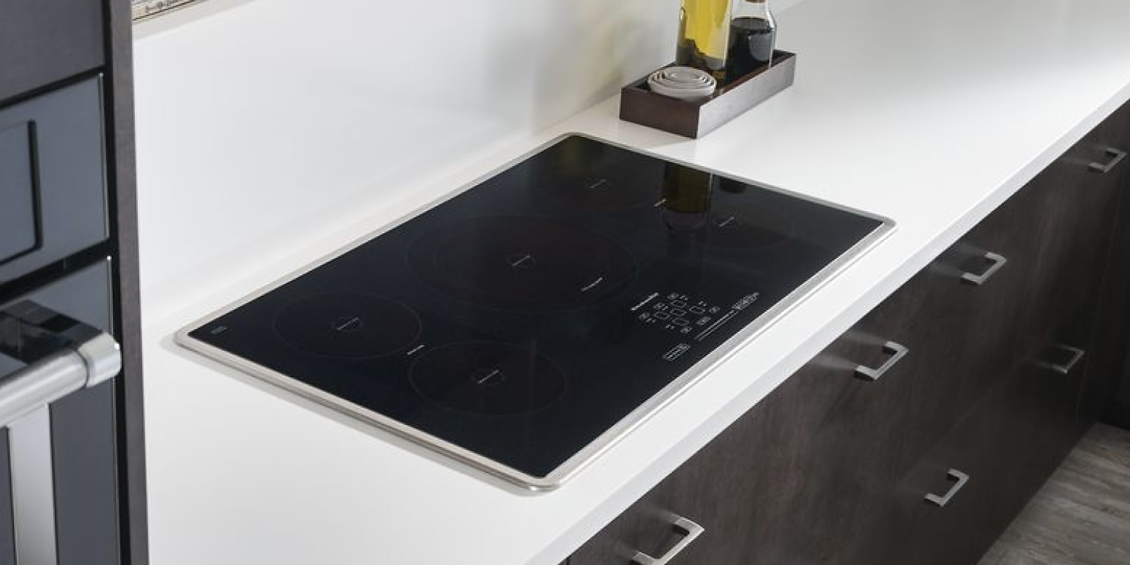 A black KitchenAid® induction cooktop installed in a white countertop.
