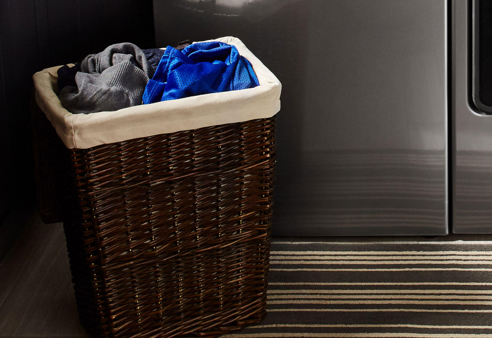 A hamper filled with laundry sorted by color