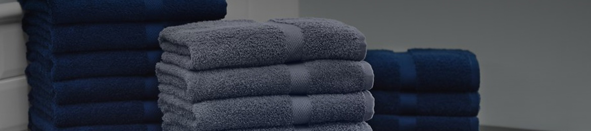 Folded blue and gray bath towels stacked in three separate piles.