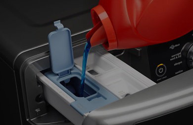 Pouring laundry detergent into a Maytag® detergent dispenser.