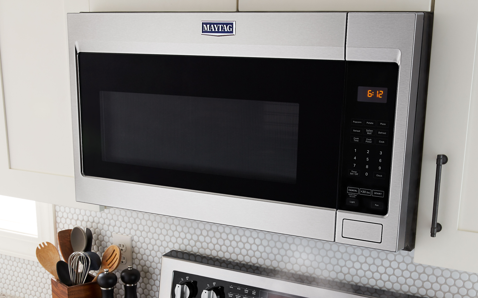 Maytag® stainless steel microwave between white cabinets