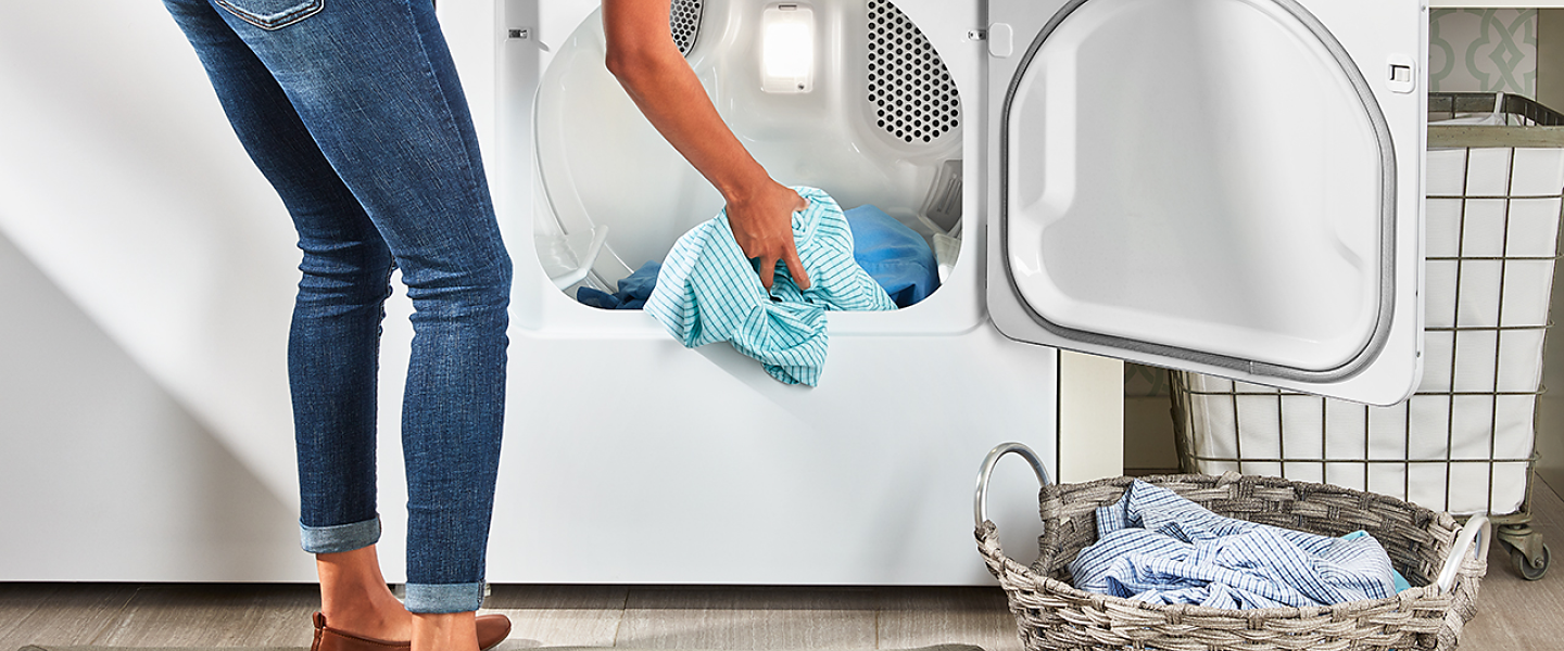 Person unloading dry laundry from a dryer.