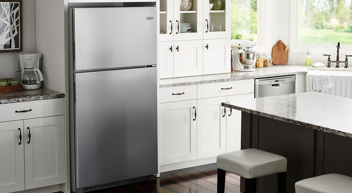Top-freezer refrigerator in a bright, white kitchen
