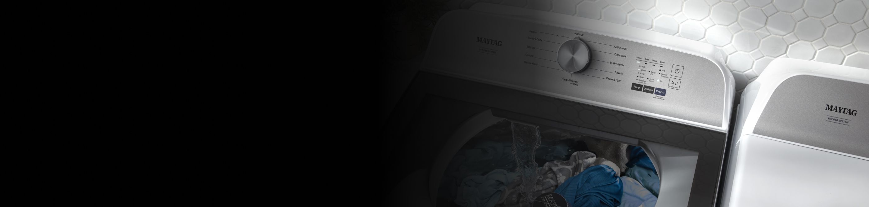 Overhead shot of large capacity Maytag® washing machine with glass lid