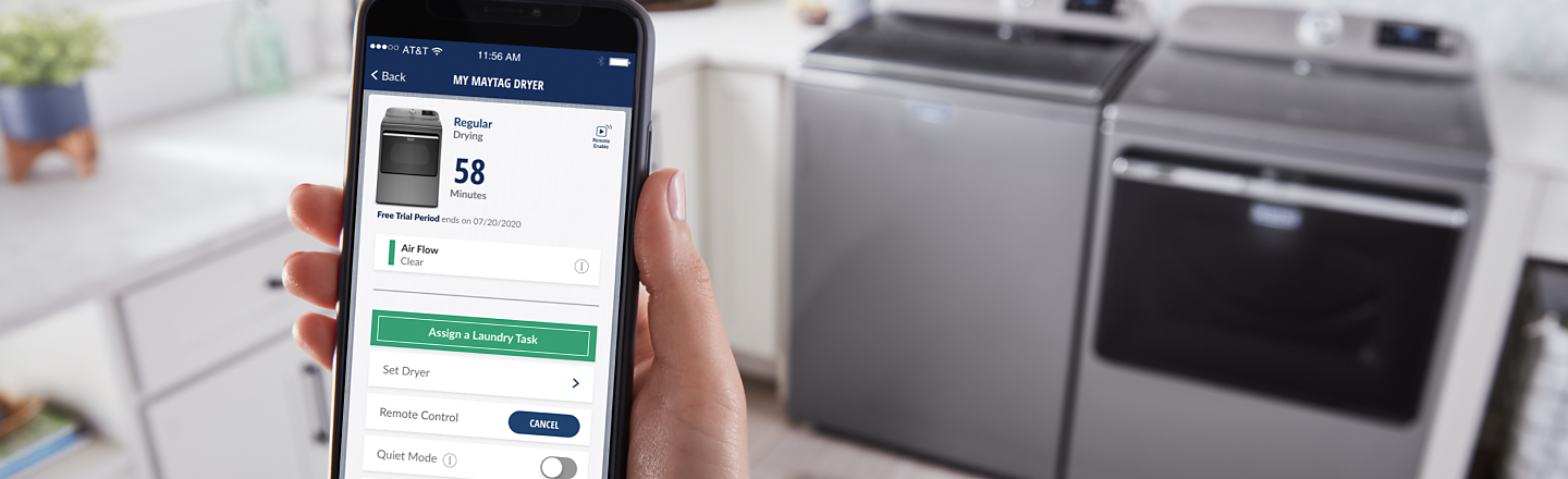 Someone using a smartphone to control a Maytag® washer and dryer