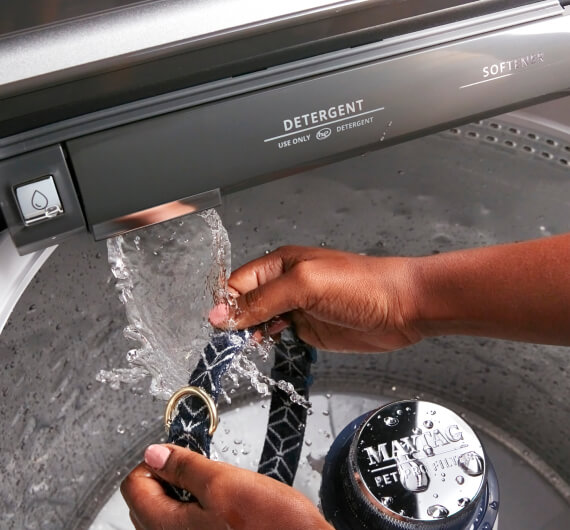 A person rinsing clothes with the built-in water faucet.