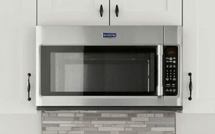 Stainless steel over-the-range microwave in a kitchen.