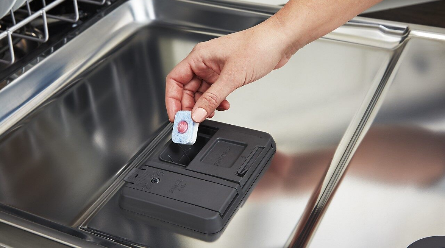 Dishwasher detergent being added to dispenser